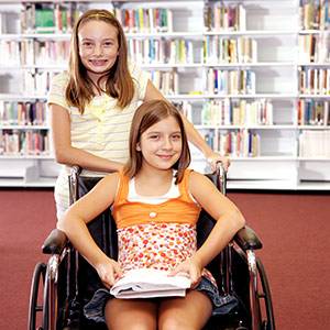 Smiling student in wheelchair with a friend.